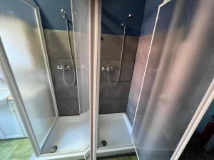 a shower with glass doors in a bathroom at Villa Egles - Villa con giardino a Lignano Sabbiadoro in Lignano Sabbiadoro +50 photos