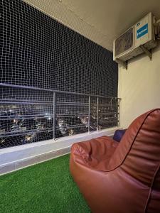 a couch in a room with a balcony with a view at Crown Suites in Greater Noida