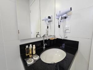 a bathroom counter with a sink and a mirror at Apartamento com Piscina no Rooftop in São Paulo +49 photos