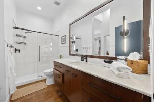 Un baño con lavabo, inodoro y espejo. en Urban Bourbon Escape - Downtown Louisville Getaway, en Louisville