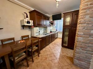 a kitchen with wooden cabinets and a table with chairs at 29 Nest Residence in Craiova