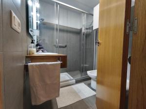 a bathroom with a shower and a sink and a toilet at Apartamento en Aldán , Playa a 2 min , Vistas a la montaña in Aldán +34 photos