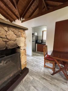a living room with a stone fireplace and a chair at Ayrampo in Mar de las Pampas