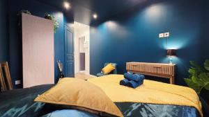 een slaapkamer met blauwe muren en een groot bed bij Suite Indigo - Centre Ville in Duinkerke