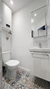 een witte badkamer met een toilet en een wastafel bij Suite Indigo - Centre Ville in Duinkerke