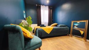 a bedroom with a bed and a mirror and a couch at Suite Indigo - Centre Ville in Dunkerque