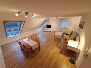 a living room with a table and a dining room at Helle, großzügige Dachgeschosswohnung in Aichtal 