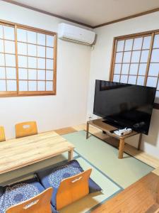 a living room with a television and a table and chairs at Wood River House 門前仲町駅 木場駅 in Tokyo