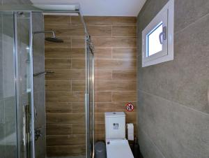 a bathroom with a toilet and a glass shower at Coral Bay Star - Direct sea location in Peyia