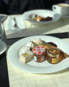 a plate of food with cheese and jam on a table at Wadi Rum Bubbles Wissam camp in Wadi Rum