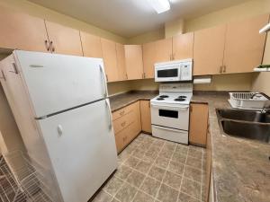 Una cocina con un refrigerador blanco y un fregadero. en Discovery Suite, en Yellowknife 5 fotos más
