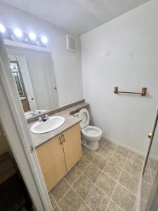 Un baño con lavabo, inodoro y espejo. en Discovery Suite, en Yellowknife