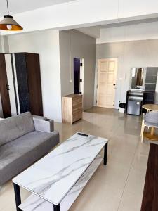 a living room with a couch and a table at Green Terrace Residence Phuket in Kathu +8 photos