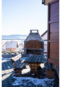 a stone fireplace on a patio with a bench at Holiday home Maša - Kupres in Kupres