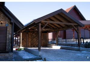 a wooden pavilion in front of a building at Holiday home Maša - Kupres in Kupres