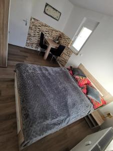 Privates Zimmer in ruhiger Lage Heidenheim-Steinheim am Albuch في Steinheim am Albuch: سرير كبير في غرفة مع طاولة