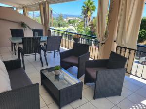 a patio with chairs and a table and a balcony at Asprokavos beach apartment and studio in Kavos