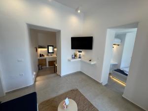 a room with a bed and a flat screen tv at Kukulú Luxurious Cottage with Mini Private Pool in Ano Mera