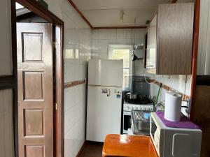 Una cocina con un refrigerador blanco y una estufa. en Cabañas Hain, en Porvenir