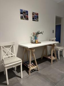 a white desk with a chair and a table and a table and chairs at Guesthouse Eekhoorn 16 in Kasterlee