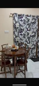 a wooden table with two chairs and a patterned wall at 2-Room Apartment in Jaffna