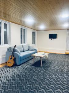 舍基House 39的客厅配有蓝色沙发和吉他