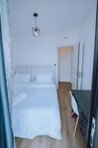 ein Schlafzimmer mit einem weißen Bett und einem Schreibtisch in der Unterkunft Shan's Comfort Sanctuary in Tatu City