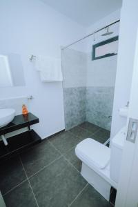 ein weißes Badezimmer mit Toilette und Waschbecken in der Unterkunft Shan's Comfort Sanctuary in Tatu City + 14 Fotos