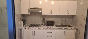 a kitchen with white cabinets and a counter top at Rabat in Temara