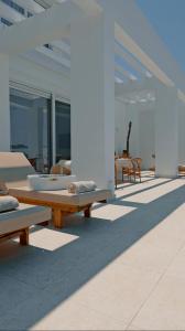 een patio met banken en tafels in een gebouw bij Seapalm Villa - Luxury Pool Retreat - 200m Beach in Lachaniá