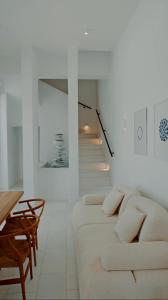 een witte woonkamer met een bank en een trap bij Seapalm Villa - Luxury Pool Retreat - 200m Beach in Lachaniá