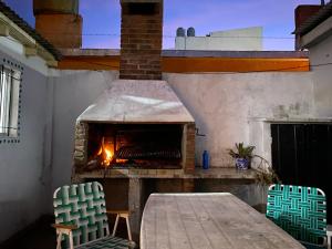 een buitenpizzaoven met twee stoelen en een tafel bij casa corazOm in Mar de Ajó