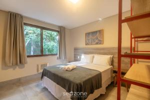 a bedroom with a bed with a stuffed animal on it at Aptos equipados em condomínio à beira-mar com área de lazer e piscina – VVAs in Arraial d'Ajuda +31 photos