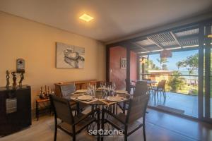 a dining room with a table and chairs and a balcony at Aptos equipados em condomínio à beira-mar com área de lazer e piscina – VVAs in Arraial d'Ajuda
