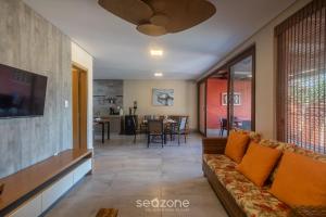 a living room with a couch and a tv at Aptos equipados em condomínio à beira-mar com área de lazer e piscina – VVAs in Arraial d'Ajuda