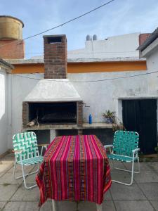 een tafel met een kleed op een terras met twee stoelen bij casa corazOm in Mar de Ajó