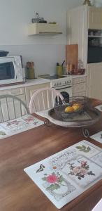 Chambre d'hôtes Le Devezou في سانت أفريك: مطبخ مع طاولة عليها سلة فواكه