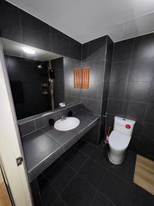 a black bathroom with a sink and a toilet at Green Terrace Residence Phuket in Kathu