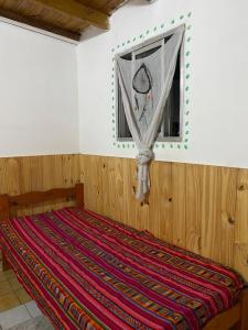 een bed in een kamer met een raam bij casa corazOm in Mar de Ajó