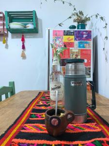 een fles en een kopje op een tafel bij casa corazOm in Mar de Ajó