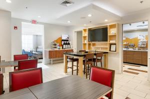 ein Wohnzimmer mit Tischen, Stühlen und einem TV in der Unterkunft Holiday Inn Express Lexington by IHG in Lexington