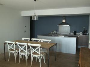 マルセイヤンにあるPort Rive Gauche Ostreaのキッチン(木製テーブル、白い椅子付)