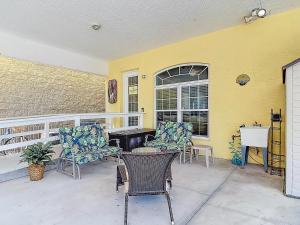 a patio with chairs and a table and a window at Inn on the Avenue in New Smyrna Beach