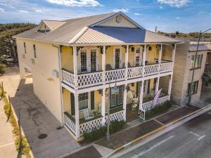 an overhead view of a yellow house with a balcony at Inn on the Avenue in New Smyrna Beach