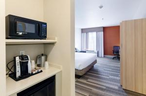ein Hotelzimmer mit einem Bett und einem Zimmer mit einem TV in der Unterkunft Holiday Inn Express Lexington by IHG in Lexington + 69 Fotos