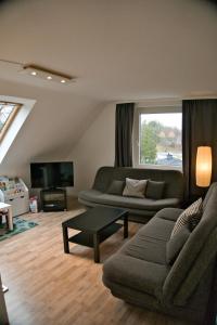 a living room with a couch and a tv at Tanne 16 - Bike & Familienurlaub in Braunlage in Braunlage