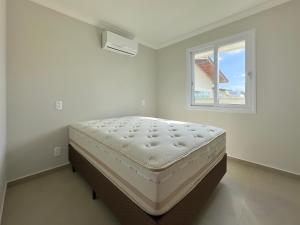 En eller flere senge i et værelse på Apê Aconchego - Capri Morada & Mar - Lateral Mar