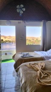 two beds in a room with a large window at Go Inn Backpackers in Aswan
