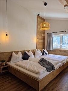 a large wooden bed in a room with a window at Lake View Lodge in Flachau