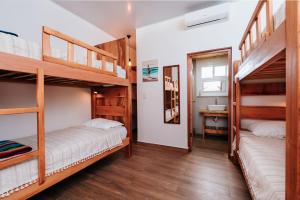 zwei Etagenbetten in einem Zimmer mit Bad in der Unterkunft Beach Break Hotel & Surf Camp de Playa Venao in Playa Venao